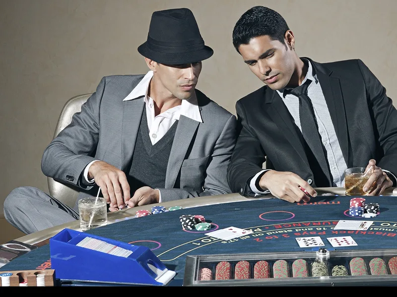 Deux hommes en costume autour d'une table de jeu