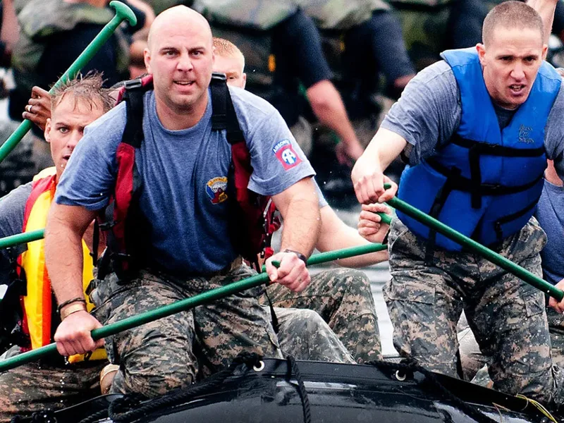 Une équipe rame ensemble sur un raft, avirons levés