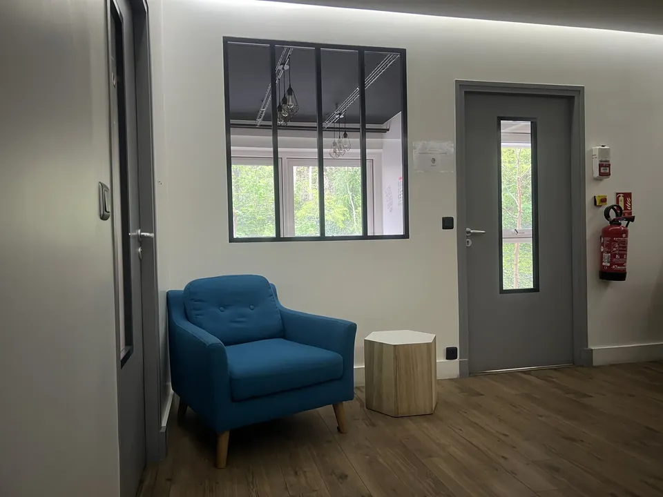 Le coin détente des locaux, fauteuil et fenêtre sur cour