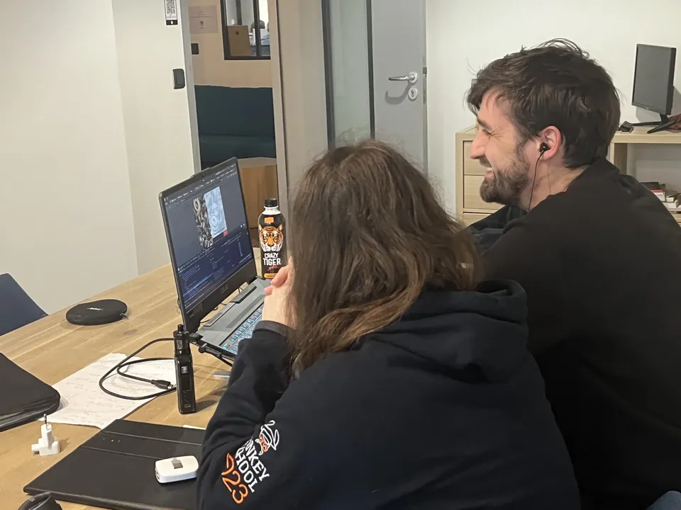 Un formateur commente un écran par-dessus l'épaule d'une élève